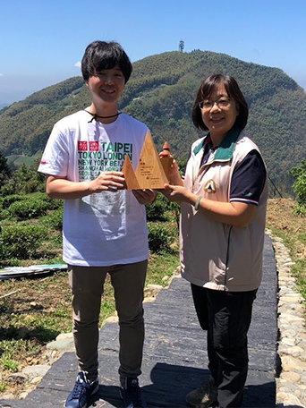 嘉義林管處康素卿課長(右)與UNIQLO及GU財務部田中智大部長率代表至造林地親手種下楓香等樹種。