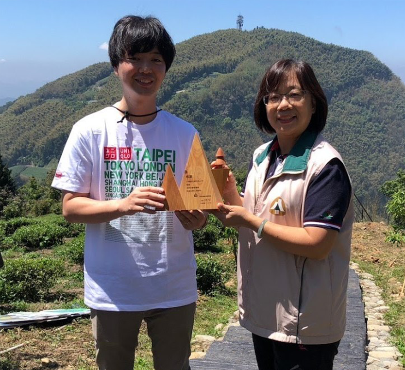 嘉義林管處康素卿課長(右)與UNIQLO及GU財務部田中智大部長率代表至造林地親手種下楓香等樹種。