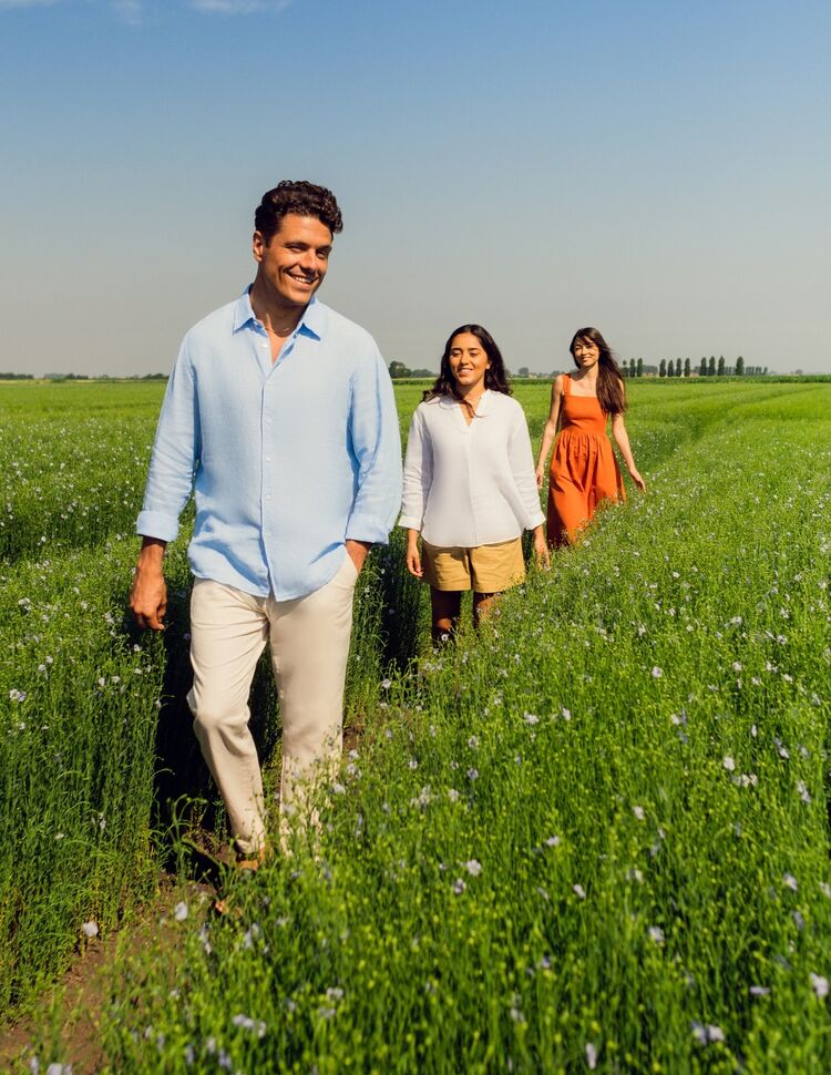 man and women in flax field wearing linen clothing