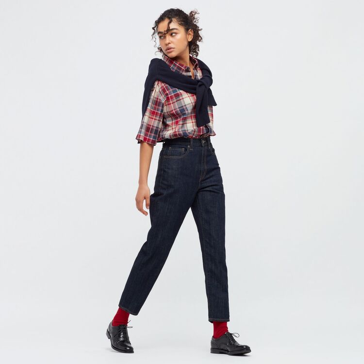 woman wearing UNIQLO mom jeans with checked shirt and jumper draped over shoulders, burgundy socks and brogues