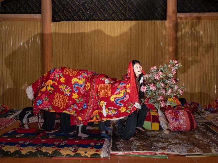  A group of students plays with their blankets creating a human dragon