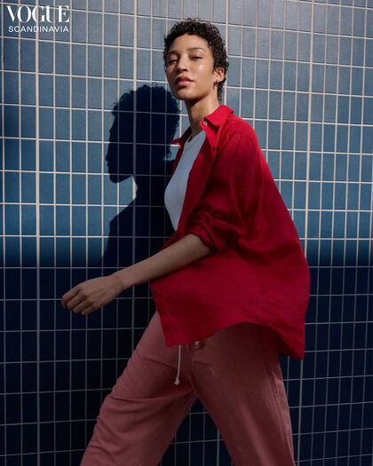 Woman wearing a casual summer look with a bright red linen shirt.