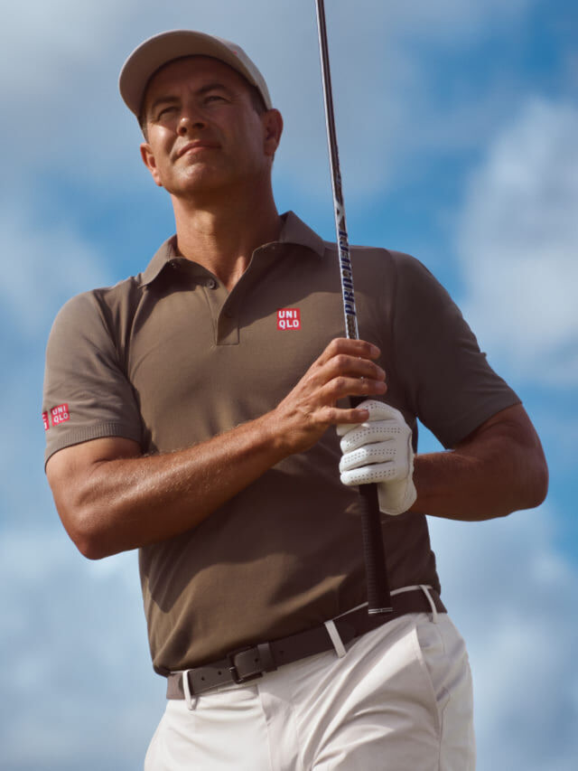 professional golfer Adam Scott wearing a dark grey UNIQLO polo shirt and cap and off white trousers