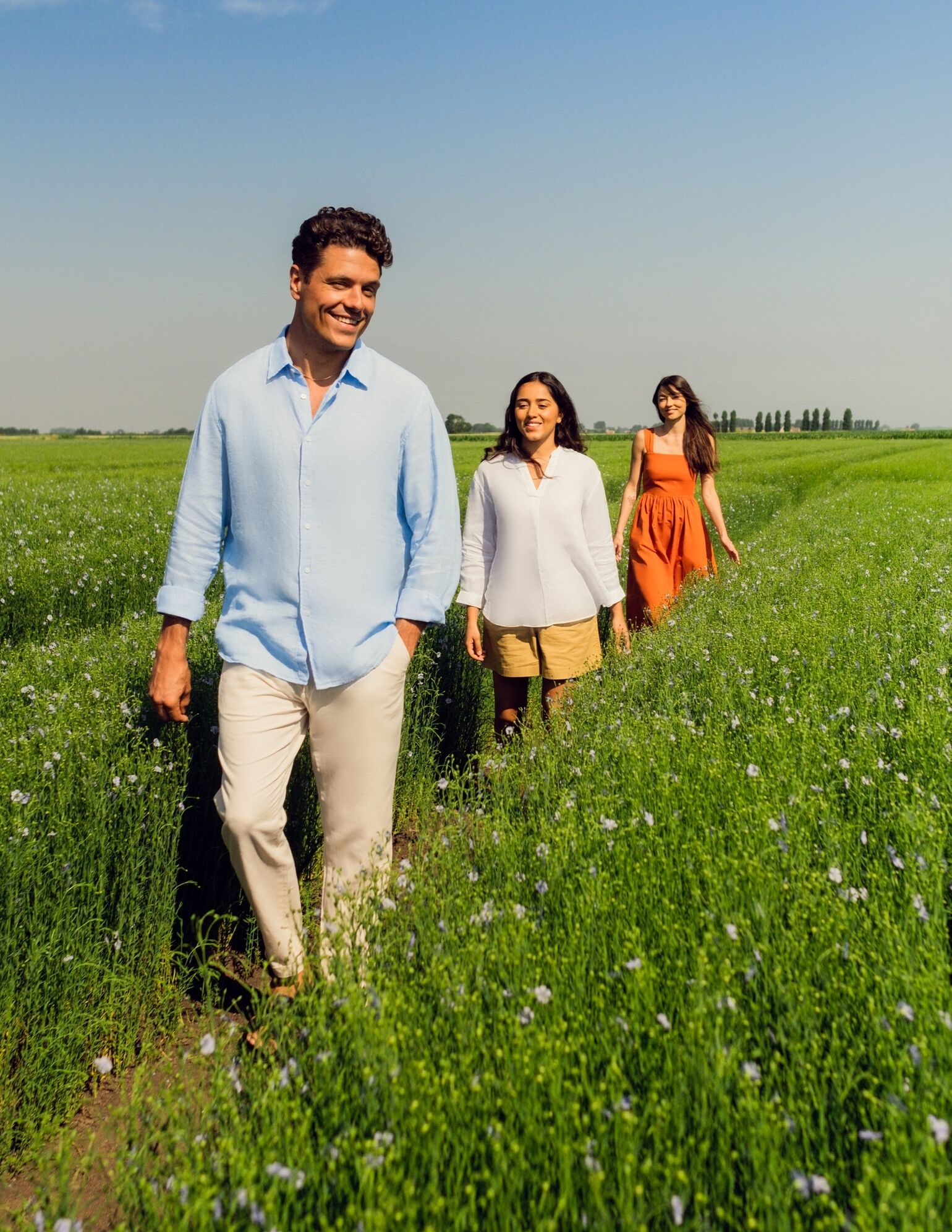 man and women in flax field wearing linen clothing