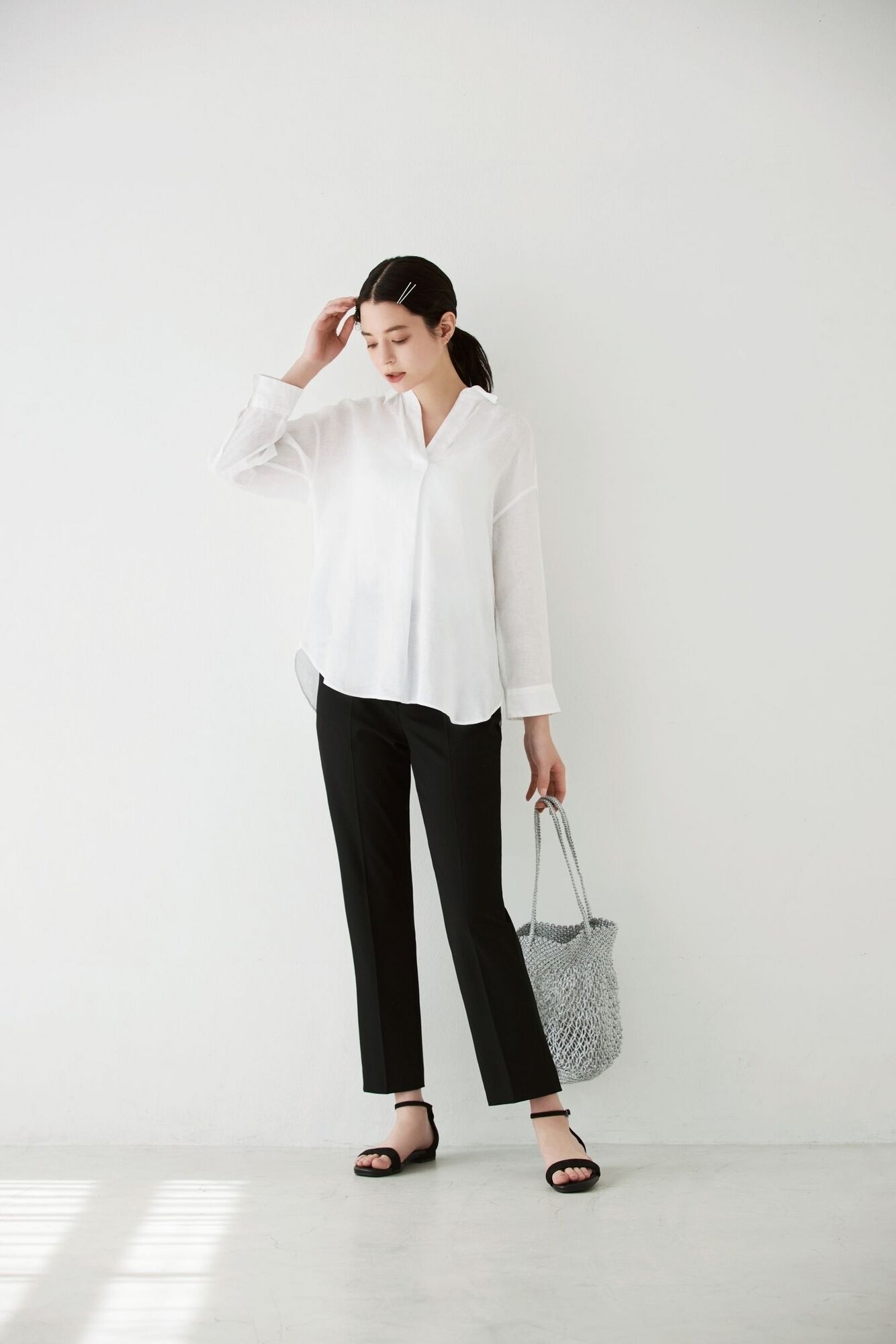 Woman wearing a white linen shirt and black trousers