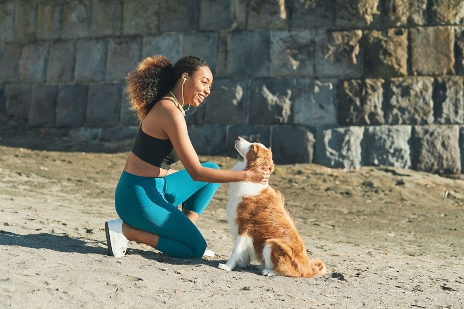 woman wearing UNIQLO activewear stroking dog