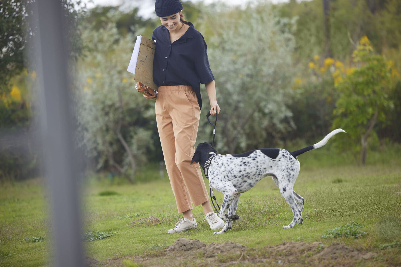 woman wearing UNIQLO clothing walking dog