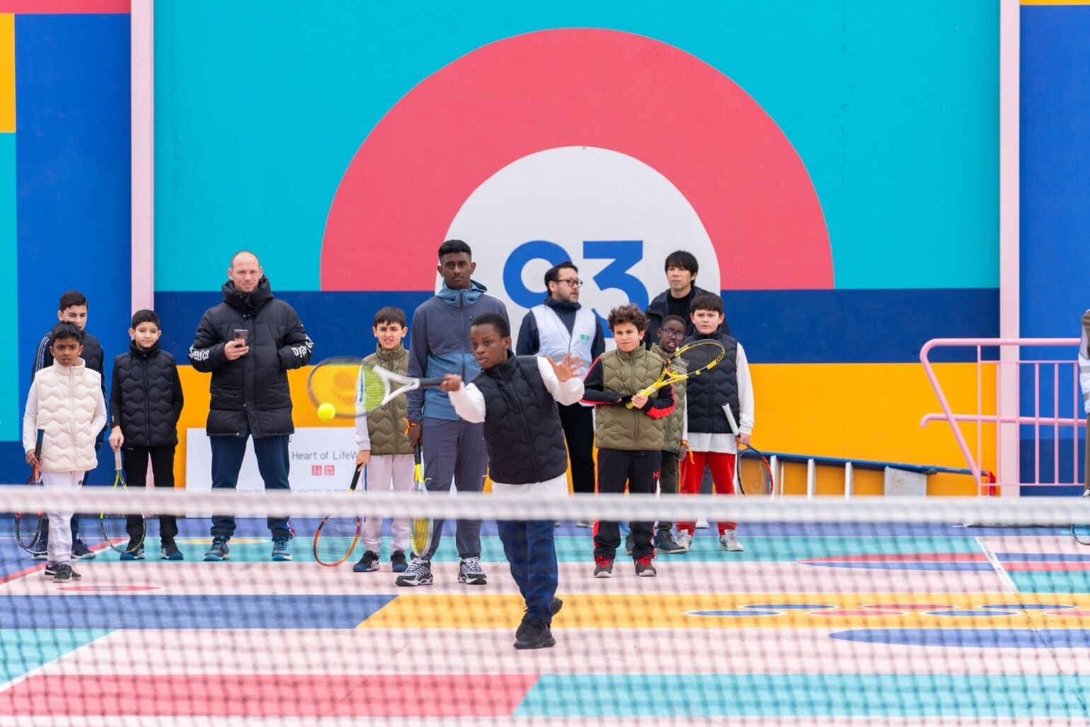 children using the new tennis court, donated by UNIQLO