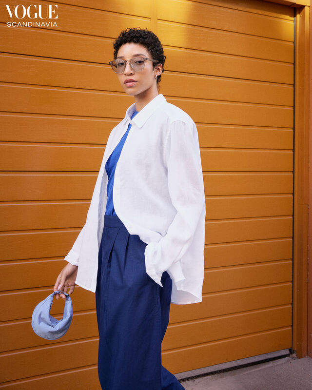 Woman wearing a casual summer look with a white linen shirt.