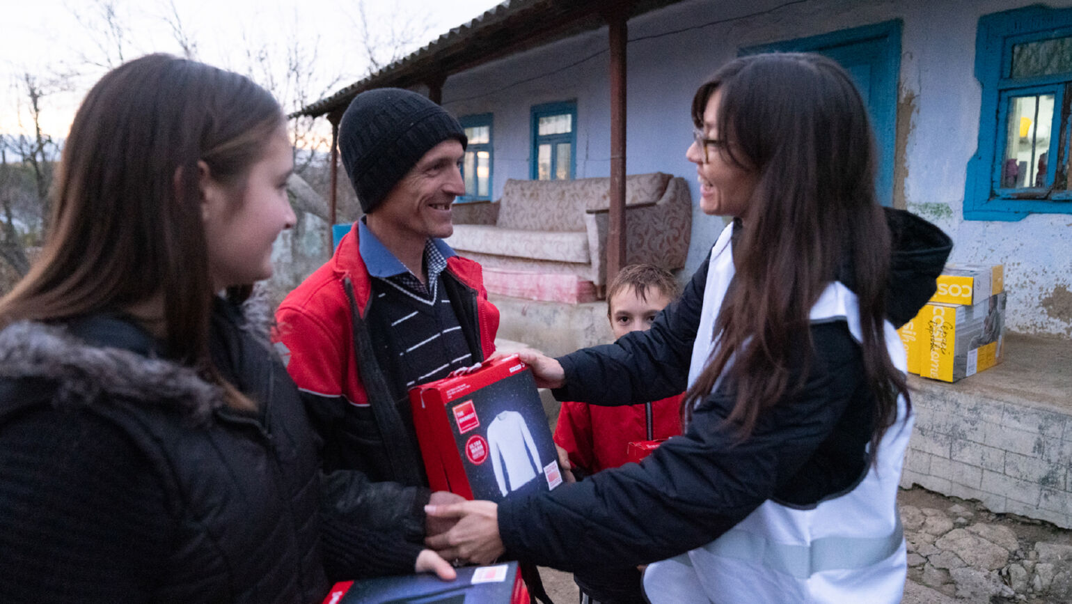 Image of a woman handing out a HEATTECH product with a smile