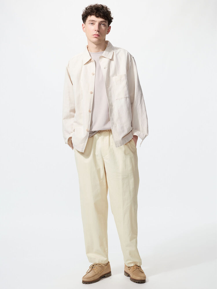 A model facing the front. Wearing a tucked in light pink shirt, a Cotton Linen Shirt Jacket in natural beige, and Linen Blend Easy Ankle Pants in natural as well.