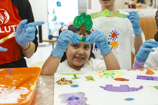 Young girl holding up a piece of art