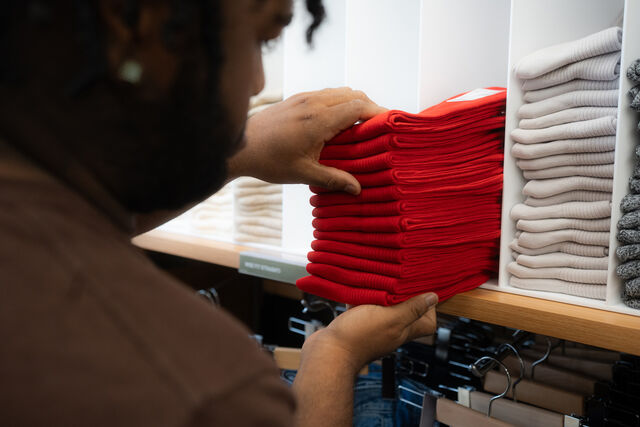 Person adding socks to a shelf