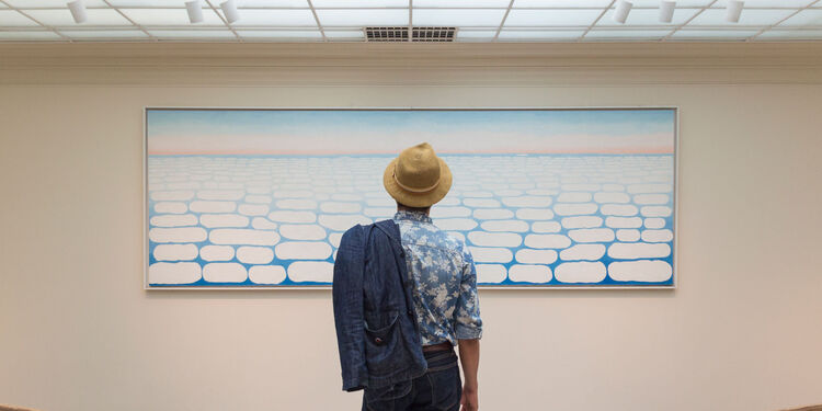 Visitor standing in front of the Sky above Clouds IV by Georgia O’Keeffe