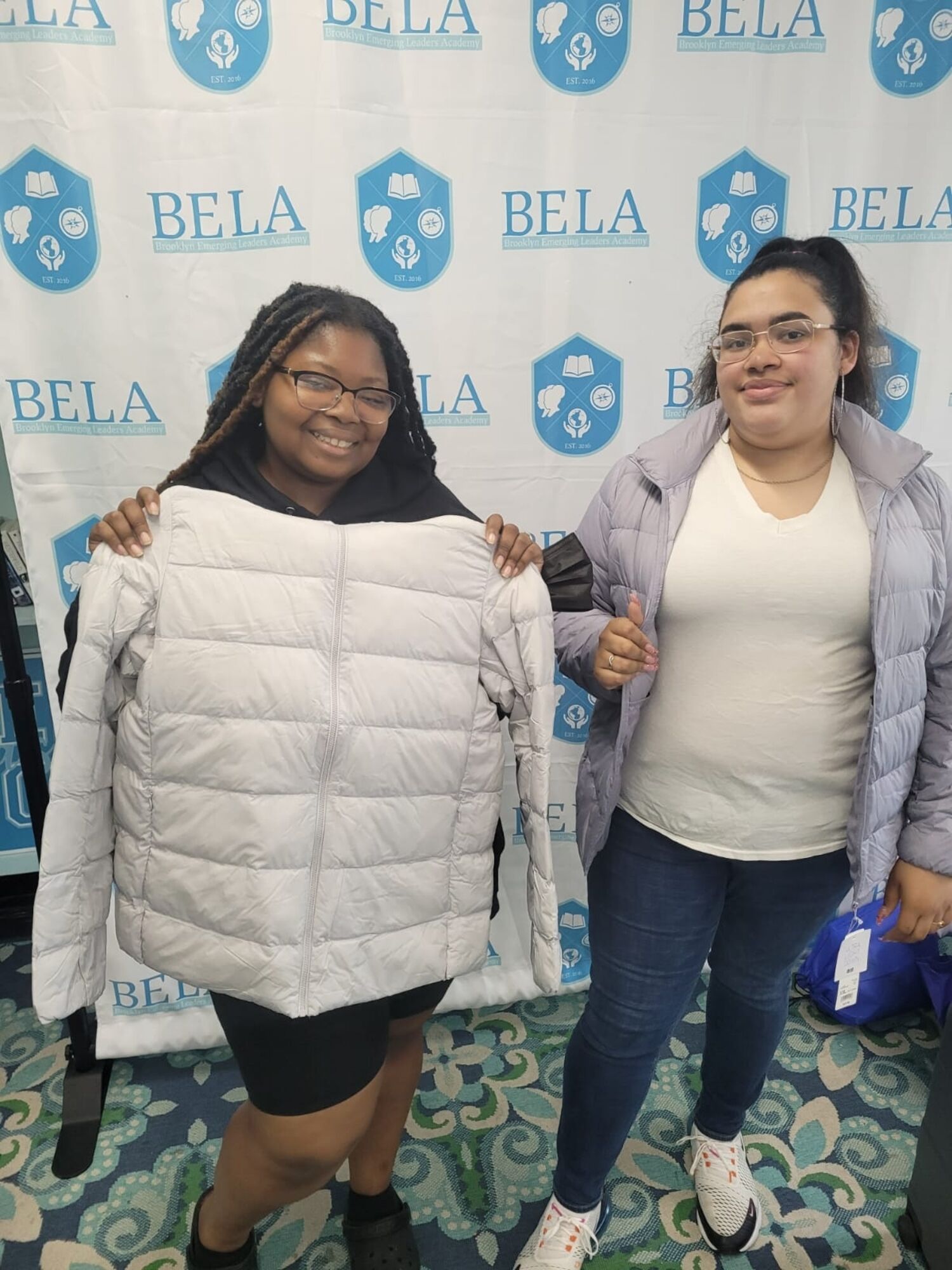 girls holding jackets