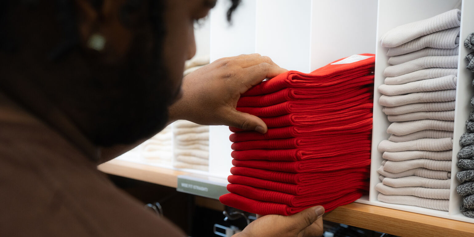 Person adding socks to a shelf