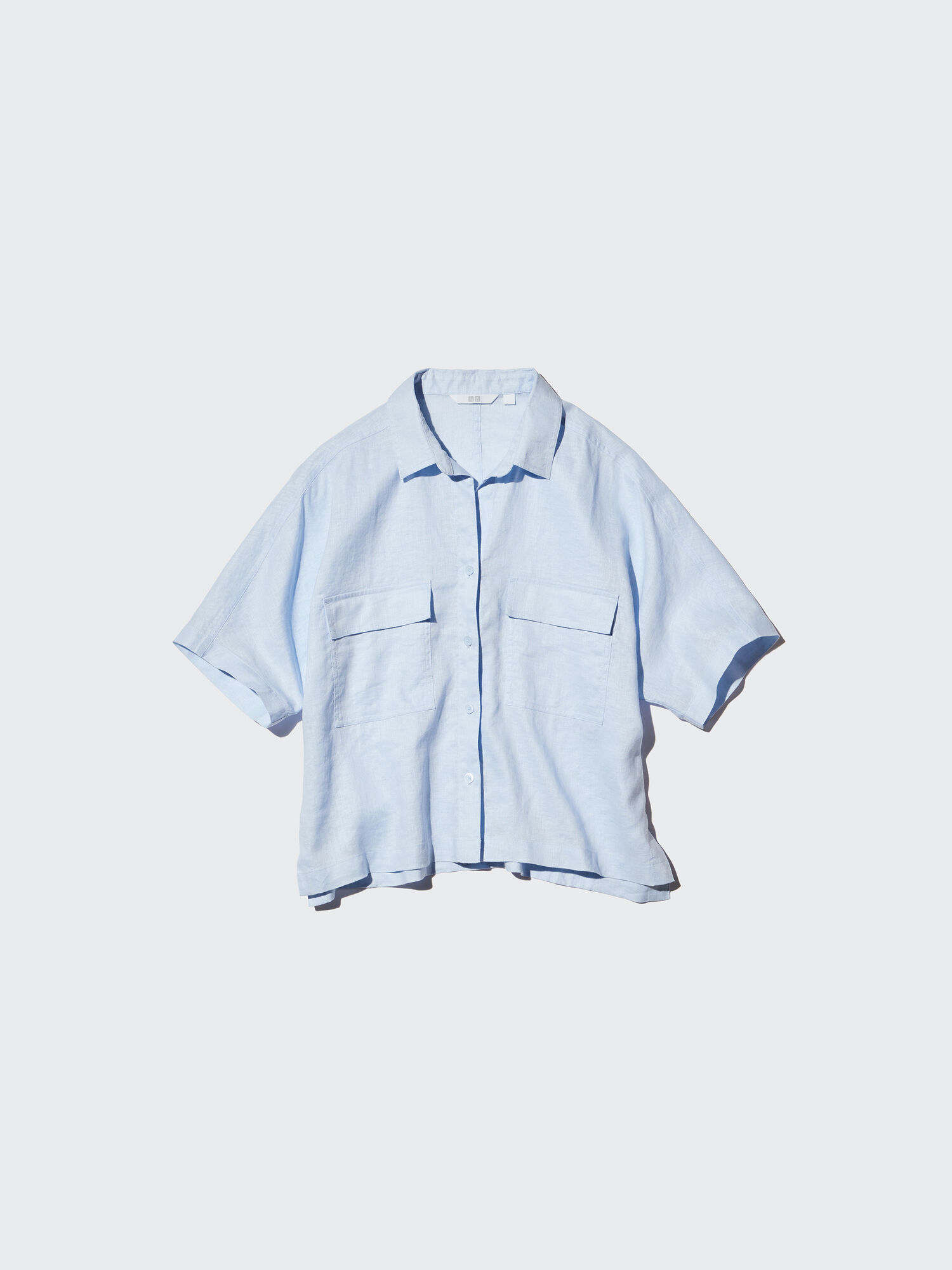 A simple product image of a clean, light blue linen shirt, photographed from the front.